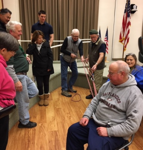 using rope and pulleys to pull a sitting man